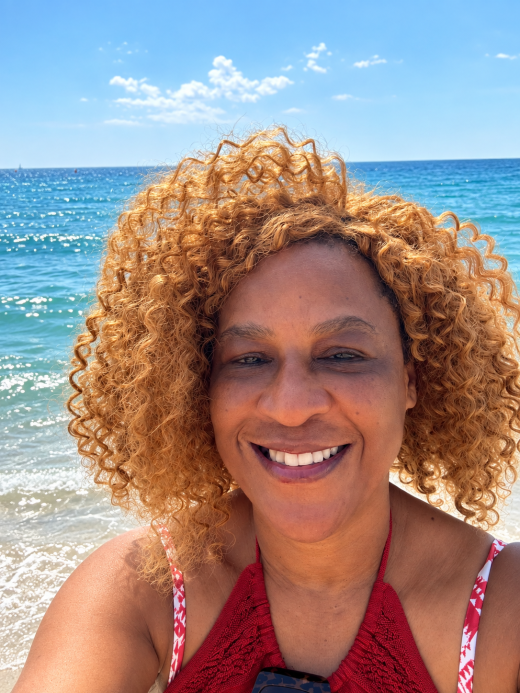 Marie-Rose Omokhodion, native French teacher, smiling beside the Mediterranean Sea in Barcelona
